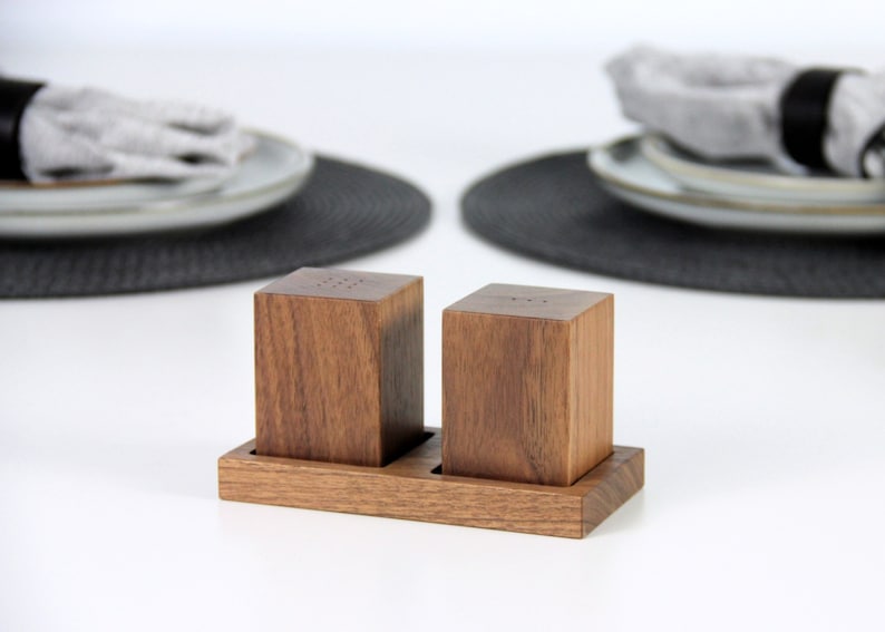 Walnut wood salt and pepper shakers with a stylish tray, perfect for seasoning your favorite dishes