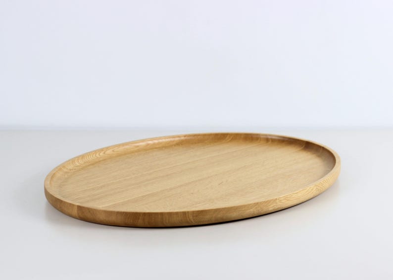 Handcrafted oval serving tray made from premium oak wood, featuring a smooth finish and natural wood grain. Perfect as a large ottoman tray, charcuterie board, or tea serving tray for home decor and entertaining