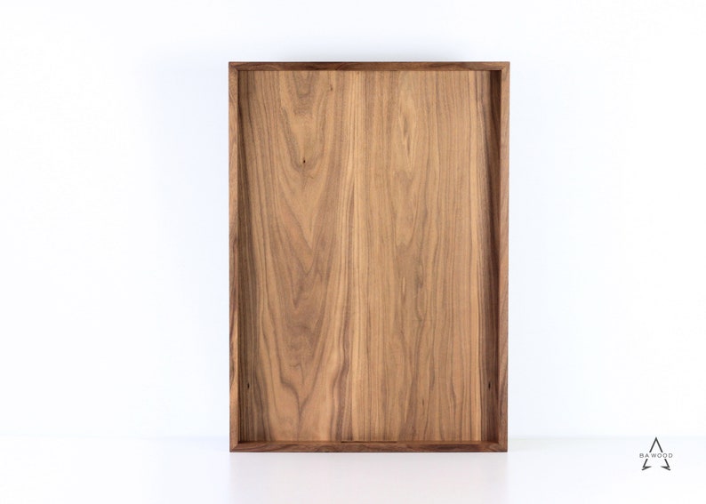 Puede incluir: Una bandeja rectangular de madera con un acabado de madera natural. La bandeja tiene un dise&ntilde;o simple y moderno y es perfecta para servir comida o bebidas.
