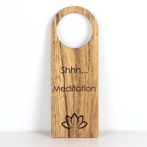 Wood door hanger with text 'Shhh.... Meditation' accompanied by a lotus symbol, creating a serene and tranquil ambiance