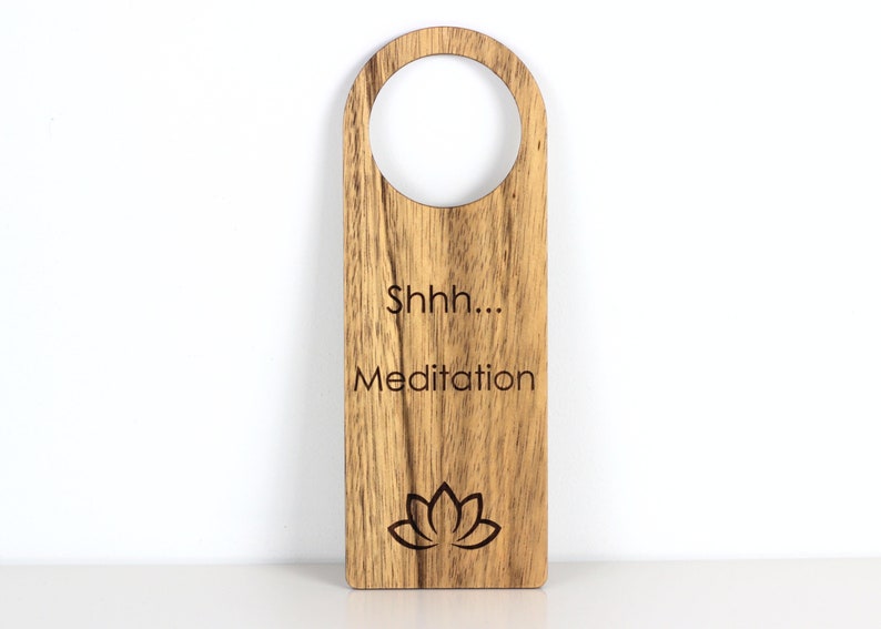 Wood door hanger with text 'Shhh.... Meditation' accompanied by a lotus symbol, creating a serene and tranquil ambiance