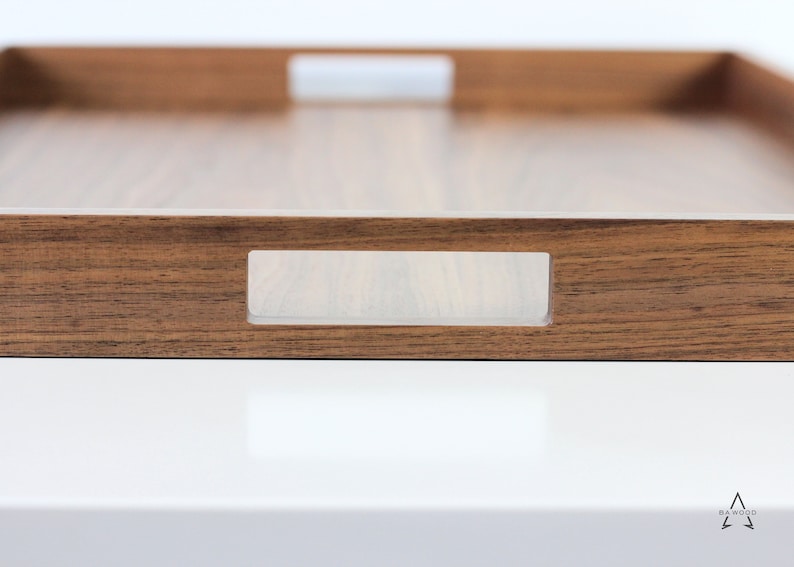 Puede incluir: Una bandeja de servir de madera con un acabado de madera natural y asas de acr&iacute;lico transparente. La bandeja tiene una forma rectangular y es perfecta para servir comida o bebidas.