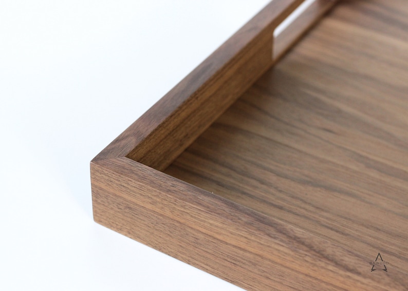 Puede incluir: Una bandeja rectangular de madera con un acabado de madera natural y un asa recortada. La bandeja est&aacute; hecha de madera maciza y tiene una superficie lisa.