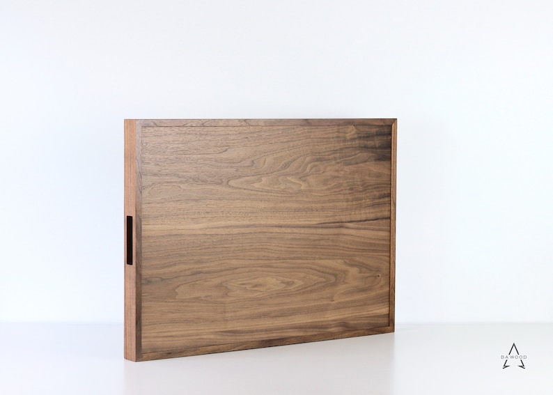 Puede incluir: Una bandeja rectangular de madera con un acabado de madera natural. La bandeja tiene un dise&ntilde;o sencillo con un borde ligeramente elevado.