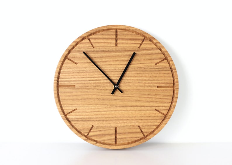 Wood wall clock with minimalist design and decorative details, perfect for adding warmth and style to any space.