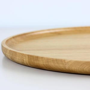 Handcrafted oval serving tray made from premium oak wood, featuring a smooth finish and natural wood grain. Perfect as a large ottoman tray, charcuterie board, or tea serving tray for home decor and entertaining