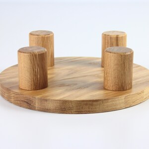 May include: A round wooden base with four wooden knobs, ideal for displaying items such as jewellery or small crafts.