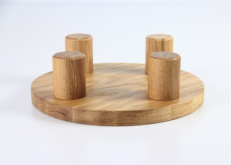 May include: A round wooden base with four wooden knobs, ideal for displaying items such as jewellery or small crafts.