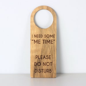Puede incluir: Un colgador de puerta de madera con el texto "Necesito algo de "tiempo para mí" Por favor, no molestar".