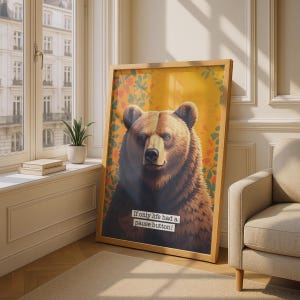 May include: A framed vertical wall art print featuring a brown bear centred against a yellow background with orange and green foliage. The text "If only life had a pause button!" is printed in a white rectangular box over the bear's chest.