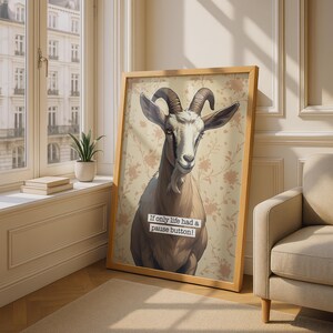 May include: A framed vertical wall art print featuring a brown and white goat against a beige floral background. The goat has curved horns and a small beard. Below the goat, a white rectangular label contains the text: If only life had a pause button!