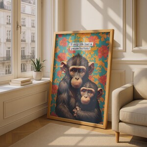 May include: A framed wall art print featuring two chimpanzees against a teal background with orange floral patterns. The text "If only life had a pause button!" is printed in a white rectangular box near the top of the artwork.