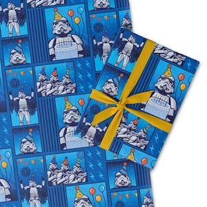 Puede incluir: Papel de regalo de cumpleaños azul con un patrón de cómic repetido de Stormtroopers con gorros de fiesta, sosteniendo pasteles y globos. Un regalo envuelto con una cinta amarilla encima. Acentos de rayos en el fondo.
