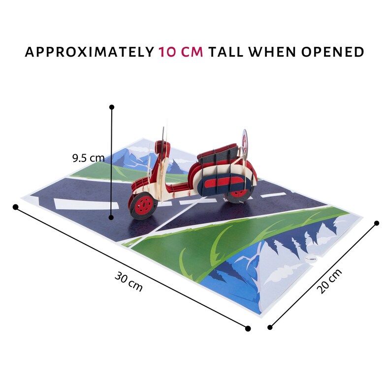 Puede incluir: Una tarjeta pop-up 3D roja y blanca con un scooter conduciendo por una carretera con monta&ntilde;as en el fondo. La tarjeta mide aproximadamente 10 cm de alto cuando est&aacute; abierta, 30 cm de ancho y 20 cm de profundidad.