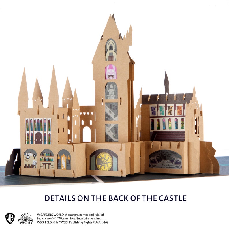 May include: A tan cardboard pop-up castle structure featuring multiple towers, arched windows, and detailed interior illustrations including potion bottles, staircases, and a circular emblem. The text "DETAILS ON THE BACK OF THE CASTLE" appears below.