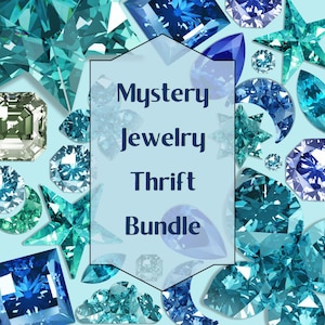 May include: A collection of blue and teal gemstones and crystals in various shapes, such as teardrops, stars, and faceted cuts. The image includes the text "Mystery Jewelry Thrift Bundle" within a central, outlined shape.