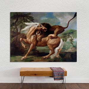 May include: A canvas print of a classical painting depicting a brown horse and a lion in a dramatic struggle. The horse has a white mane and tail, and the lion is atop the horse. The background features trees and a cloudy sky.
