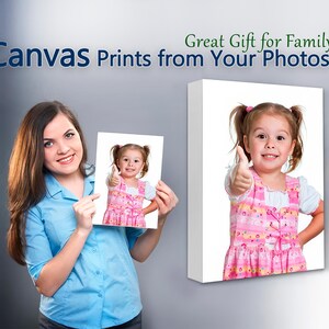 May include: A woman is holding a canvas print of a young girl giving a thumbs up. The print is on a white background. The text "Great Gift for Family Canvas Prints from Your Photos" is at the top of the image.