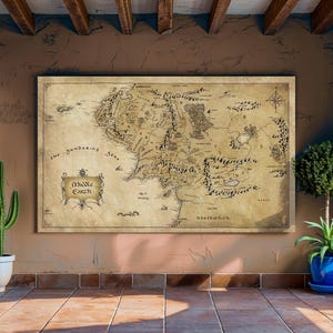 May include: A large framed map of Middle Earth, with detailed illustrations of the fictional world. The map is in sepia tones, with black lettering and illustrations. The words "Middle Earth" are in a decorative banner. The map is displayed on a brown wall.