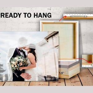 May include: A canvas print of a wedding couple kissing under a white veil. The print is ready to hang and has a 1.5 inch wood frame.