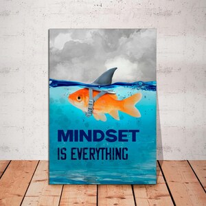 May include: A motivational poster with a blue and white watercolor background. A goldfish wearing a shark fin is swimming in the water. The text "MINDSET IS EVERYTHING" is printed in blue letters.