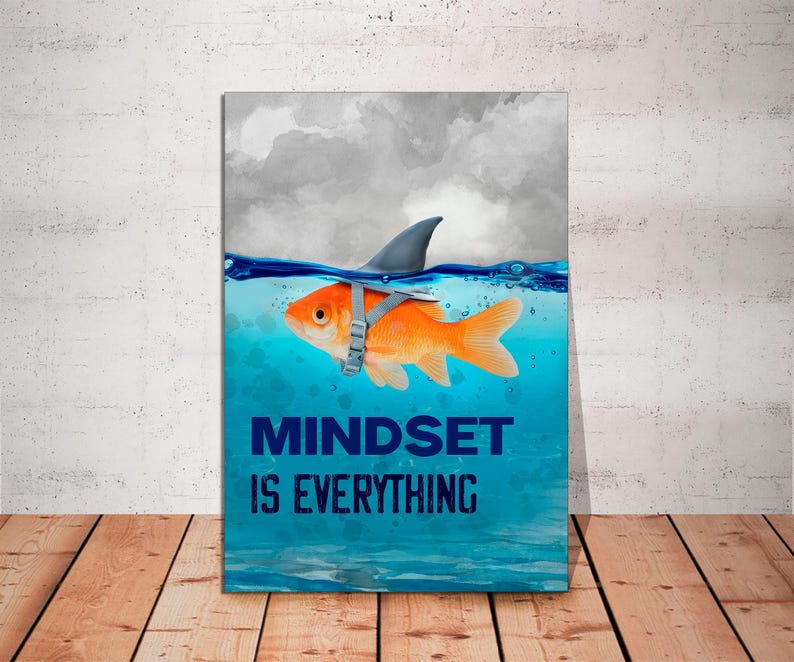 May include: A motivational poster with a blue and white watercolor background. A goldfish wearing a shark fin is swimming in the water. The text "MINDSET IS EVERYTHING" is printed in blue letters.