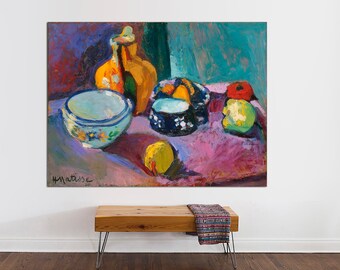 May include: A still life painting by Henri Matisse featuring a blue and white bowl, a yellow and brown jug, a blue and white bowl with a fruit inside, a red and green pepper, and a yellow lemon on a purple tablecloth. The painting is signed "H. Matisse" in the bottom left corner.