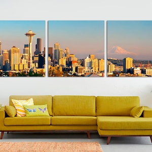 May include: A three-panel canvas print featuring a cityscape with a view of the Space Needle and Mount Rainier in the distance. The cityscape is a mix of modern and traditional buildings, with a variety of colors and textures. The print is perfect for adding a touch of urban sophistication to any room.