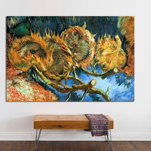May include: A painting of wilted sunflowers in shades of yellow, brown, and blue. The sunflowers are arranged in a cluster, with their heads drooping and their petals falling off. The background is a dark blue, with hints of green and yellow.
