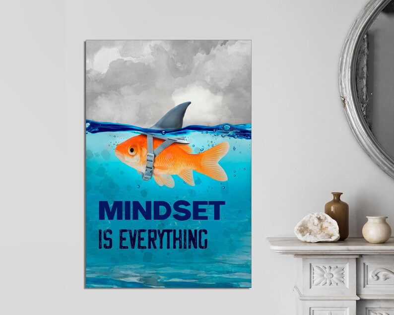 May include: A motivational poster with a gold fish wearing a shark fin and the text "Mindset is Everything" in blue letters. The fish is swimming in blue water with a cloudy sky in the background.