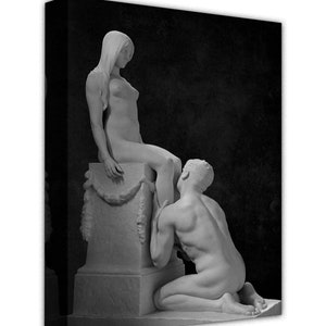 May include: Black and white photograph of a sculpture depicting a man kneeling and looking up at a woman standing on a pedestal.