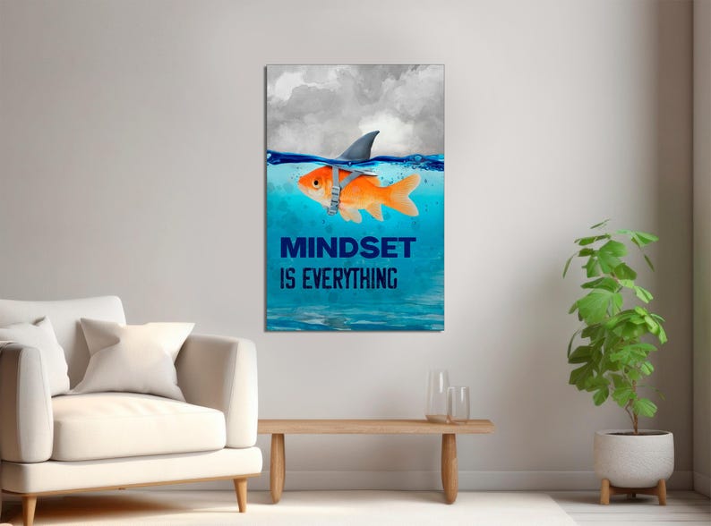 May include: A motivational poster with a goldfish wearing a shark fin and the text "Mindset is Everything". The goldfish is swimming in blue water with white clouds in the background.