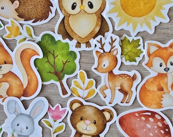 May include: A set of 11 woodland animal and nature themed stickers. The stickers feature a brown hedgehog, a brown owl, a yellow sun, a green tree, a brown bear, a gray rabbit, a red mushroom, a brown deer, a brown squirrel, a green leaf, and a brown fox.