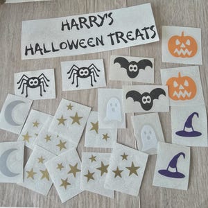 May include: A collection of Halloween-themed stickers featuring pumpkins, bats, spiders, ghosts, stars, moons, and witch hats. The stickers are in various colors, including orange, black, white, gold, and purple. The text "HARRY'S HALLOWEEN TREATS" is also present.