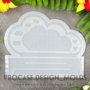 Op de afbeelding: Een transparante siliconen mal in de vorm van een wolk met een gestippeld oppervlak en drie kleine wolkvormen. De mal heeft een rechthoekige basis met de tekst "PROCASE.DESIGN.MOLDS HANDMADE SILICONE MOLDS" erop gedrukt.