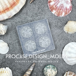 Puede incluir: Molde de silicona transparente con cuatro impresiones circulares de un diseño de dólar de arena. El molde está sobre un fondo gris con conchas alrededor. El texto "PROCASE.DESIGN_MOLDS" y "HANDMADE SILICONE MOLDS" está impreso en el molde.