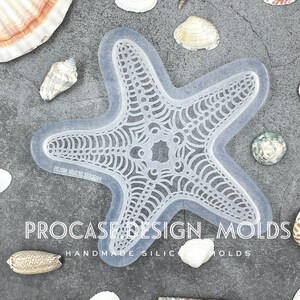 May include: A clear silicone mold shaped like a starfish with a detailed, intricate design. The mold is on a gray background with seashells scattered around it. The text "PROCASE DESIGN MOLDS HANDMADE SILIC MOLDS" is visible at the bottom of the image.