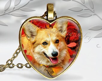 May include: Bronze-toned heart pendant with a smiling corgi dog image, set against red and orange autumn leaves. The pendant hangs from a matching chain. The text "slrfreespiritjewelry.etsy.com" is at the bottom.