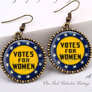 以下が含まれることがあります： 白い星と「Votes for Women」の文字が書かれた青と黄色の丸いペンダントが付いた、ゴールドトーンのイヤリングのペアです。