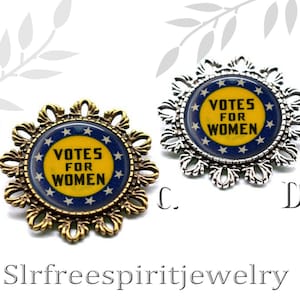 May include: Two gold and silver tone brooches with a blue and yellow circular design. The design features a circle with white stars and the text "Votes for Women".