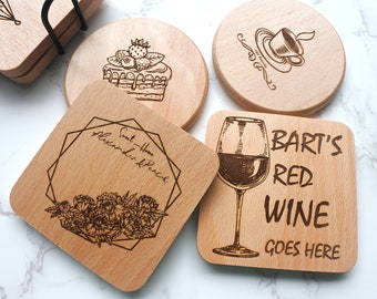 Könnte beinhalten: Vier Untersetzer aus Holz mit lasergravierten Designs. Ein Untersetzer zeigt einen Kuchen mit Erdbeeren und dem Text "Sweet Home Alexander & Peach". Ein weiterer Untersetzer zeigt ein Weinglas mit dem Text "Bart's Red Wine Goes Here". Ein dritter Untersetzer zeigt eine Kaffeetasse mit dem Text "The Family". Der vierte Untersetzer zeigt ein Blumenmuster mit einem geometrischen Rahmen.