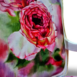 May include: A white chair with a floral patterned fabric seat. The fabric features a large pink rose with white petals and green leaves. The background is a watercolor wash of pink, purple, and green.