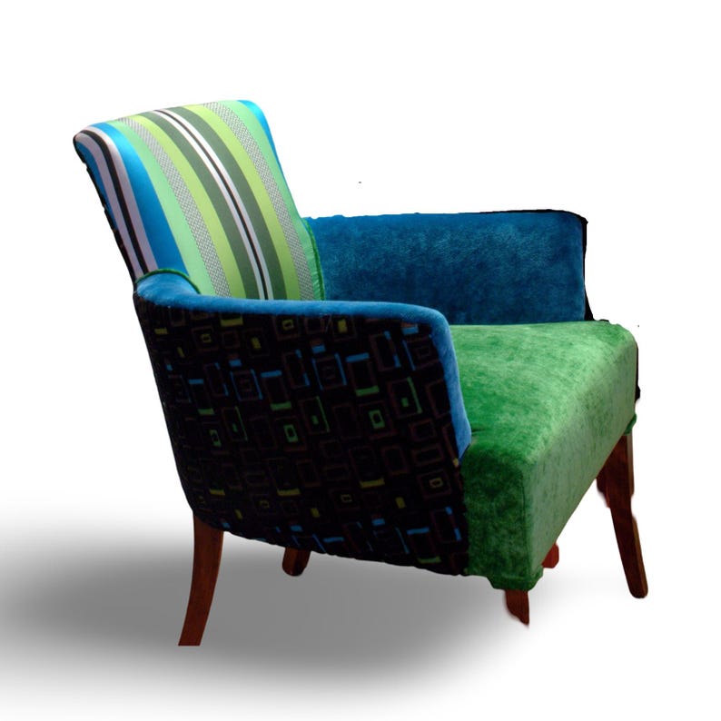 Op de afbeelding: Een kleurrijke fauteuil met een gestreepte rugleuning, een armleuning met geometrisch patroon en een groene zitting. De stoel heeft houten poten.