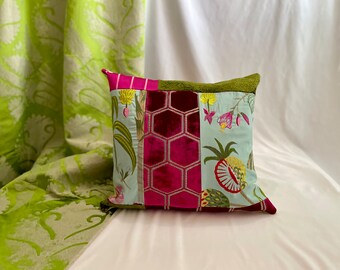 May include: A patchwork pillow with a floral design in shades of pink, green, and blue. The pillow is made of velvet and cotton fabrics and features a honeycomb pattern.