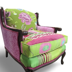 May include: A pink and green patterned armchair with a wooden frame. The chair has a high back and a floral design on the fabric.