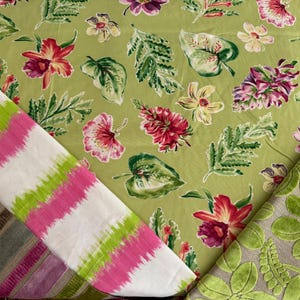 May include: An assortment of floral and patterned fabrics. One fabric features a light green background with red, pink, and purple flowers and green leaves. Another has pink and green stripes on a white background. A third fabric has green leaves.