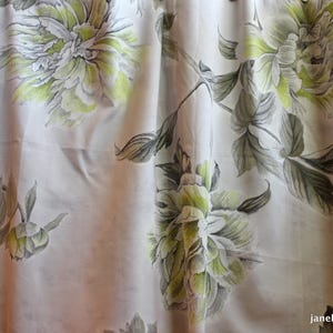 May include: White fabric with a floral pattern of green and gray peonies. The fabric has a subtle sheen and a soft texture.