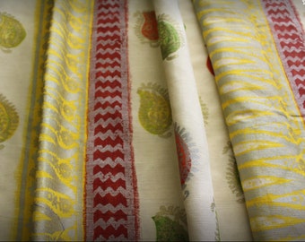 Peut inclure: Tissu blanc à rayures jaunes, rouges et vertes. Le tissu a un motif paisley.