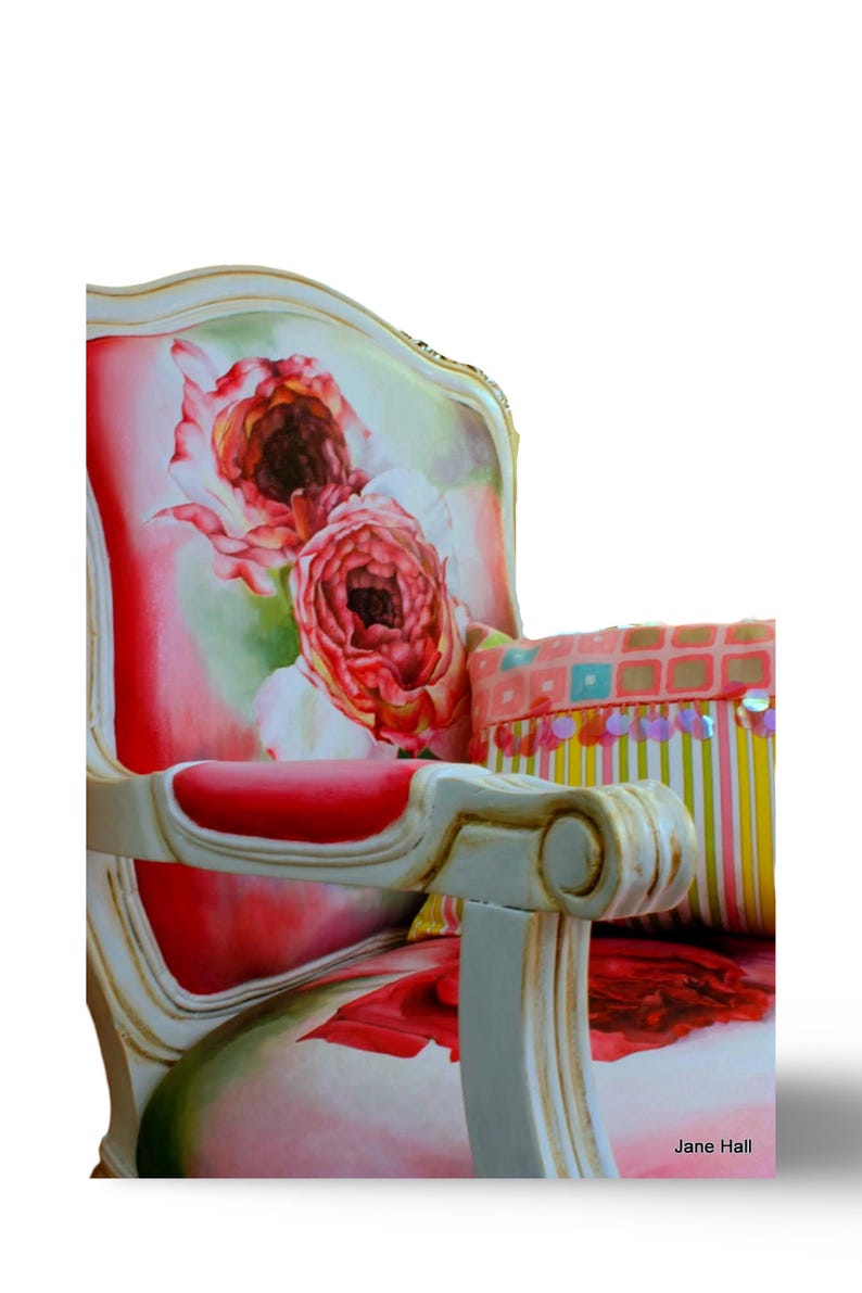 May include: A white, ornate chair with a floral patterned upholstery featuring pink and red roses. The chair has a red cushion and a colorful striped pillow with sequins.
