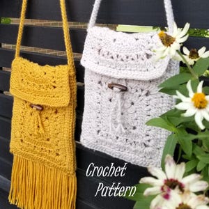 Può includere: Due borse a tracolla all'uncinetto fatte a mano. Una è giallo senape con frange, l'altra è grigio chiaro. Entrambe hanno chiusure a levetta in legno e lunghe cinghie. Il testo "Crochet Pattern" è visibile.